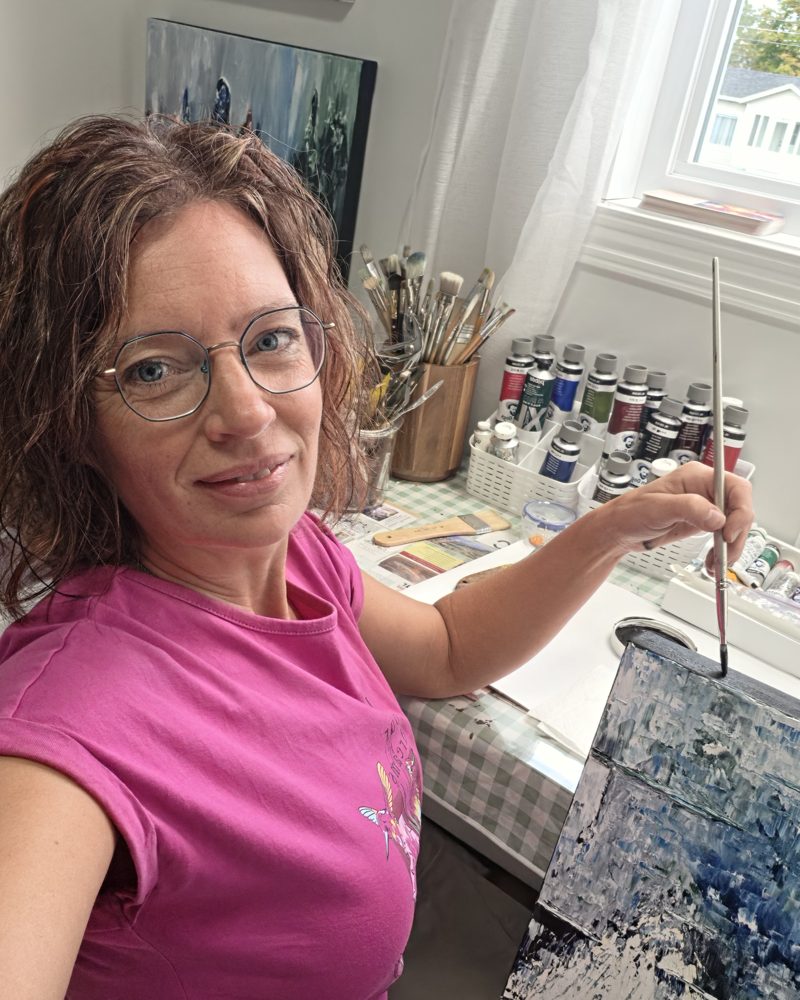 Rouleau dans son atelier, pinceau à la main, devant une toile en cours